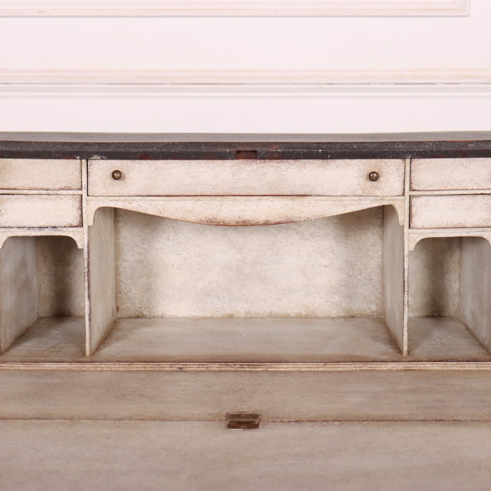 A small painted English bureau secretaire featuring a dark grey exterior, three lower drawers with brass handles, and a drop-front slant lid opening to a cream fitted interior with pigeonholes. View VI