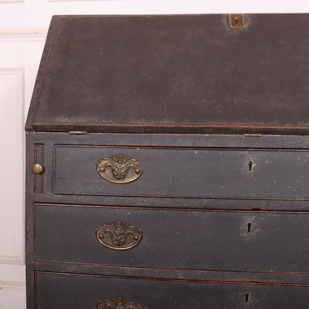 A small painted English bureau secretaire featuring a dark grey exterior, three lower drawers with brass handles, and a drop-front slant lid opening to a cream fitted interior with pigeonholes. View VII