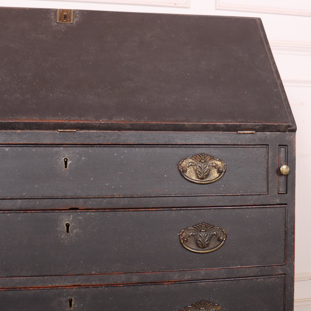 A small painted English bureau secretaire featuring a dark grey exterior, three lower drawers with brass handles, and a drop-front slant lid opening to a cream fitted interior with pigeonholes. View IX