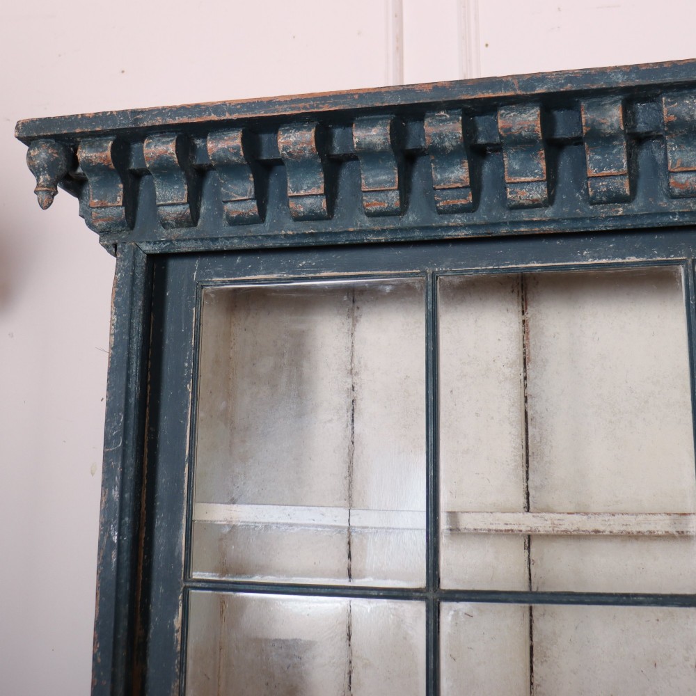 A large two-part dark blue painted timber dresser featuring a glazed upper display section with grid-paned doors and a dentil corniced top, resting on a base with three drawers and three panelled cupboard doors. View IX