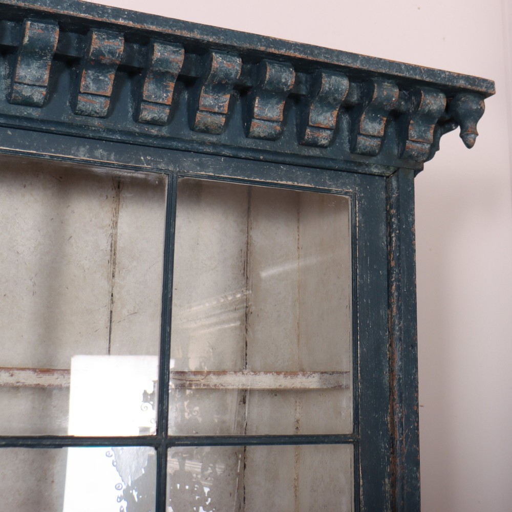 A large two-part dark blue painted timber dresser featuring a glazed upper display section with grid-paned doors and a dentil corniced top, resting on a base with three drawers and three panelled cupboard doors. View X