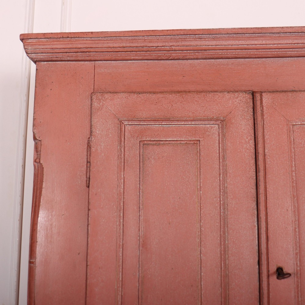 A two-piece Danish bureau bookcase featuring a terracotta red painted finish, upper panelled double cupboard doors, a cylinder roll-top desk centre, and three long drawers below. View II