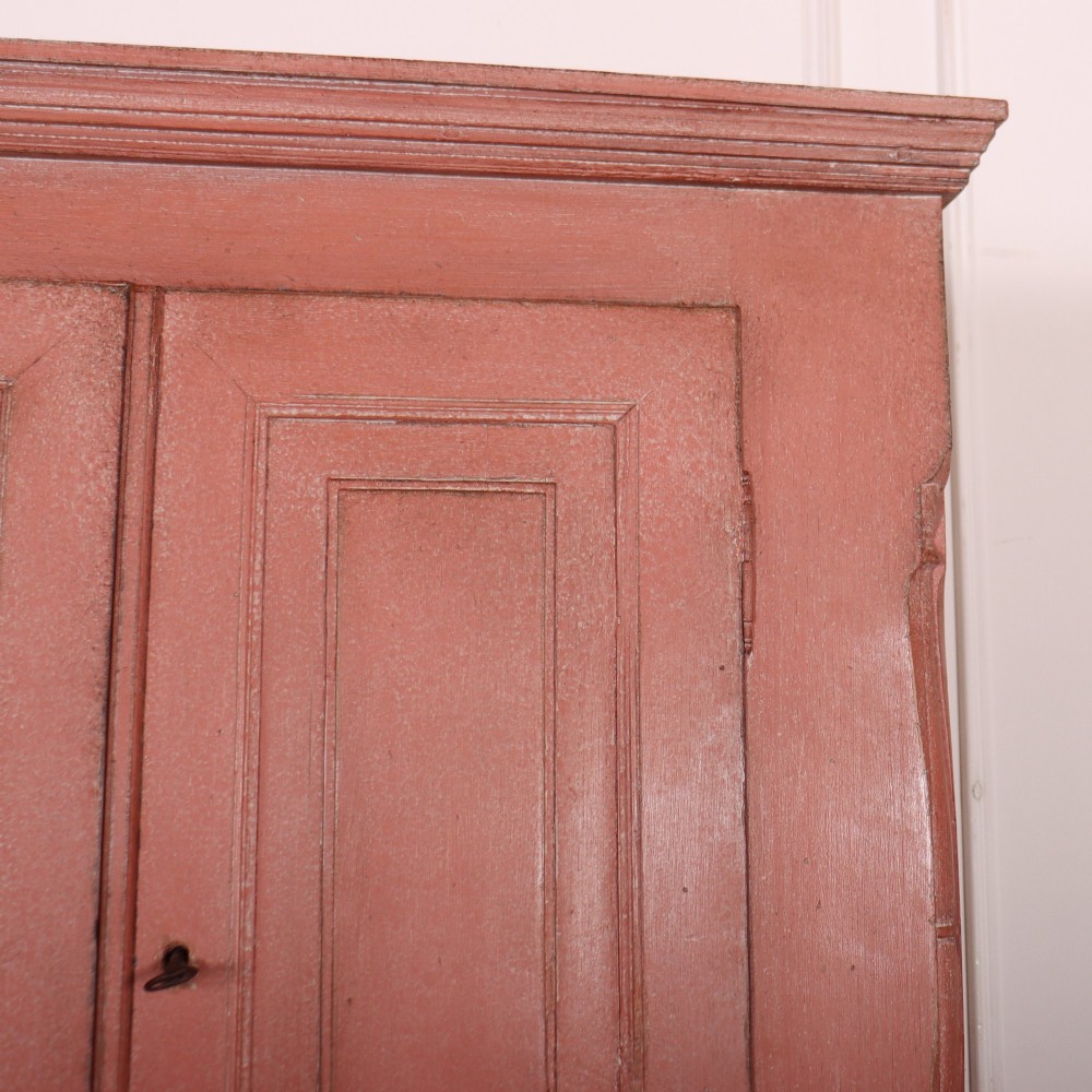 A two-piece Danish bureau bookcase featuring a terracotta red painted finish, upper panelled double cupboard doors, a cylinder roll-top desk centre, and three long drawers below. View III