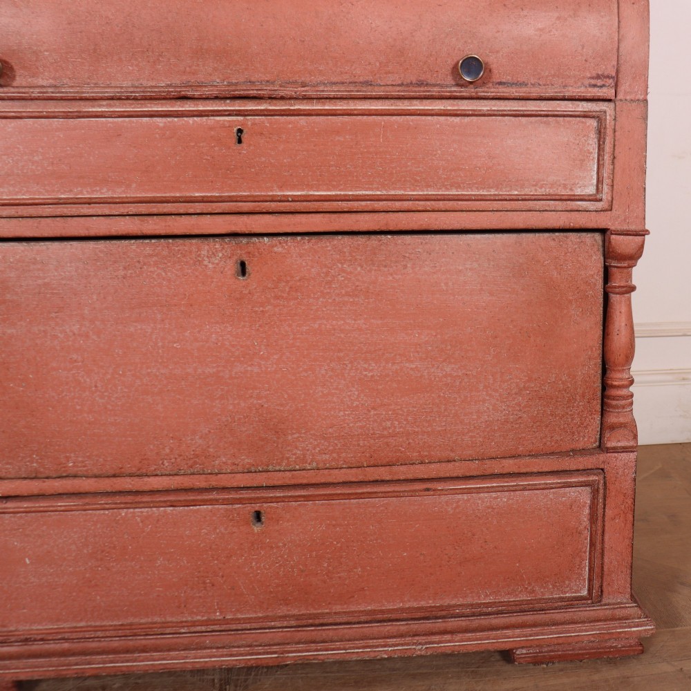 A two-piece Danish bureau bookcase featuring a terracotta red painted finish, upper panelled double cupboard doors, a cylinder roll-top desk centre, and three long drawers below. View VIII