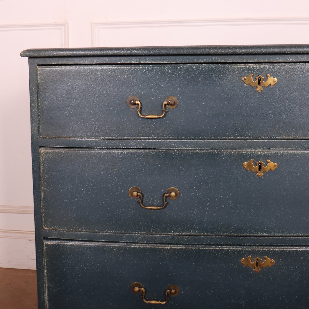 A three-drawer painted wooden chest featuring a dark blue painted finish, brass swan-neck handles, and shaped bracket feet. View II