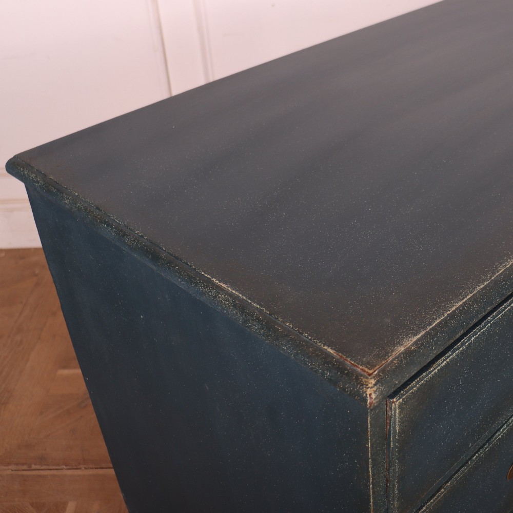 A three-drawer painted wooden chest featuring a dark blue painted finish, brass swan-neck handles, and shaped bracket feet. View VIII