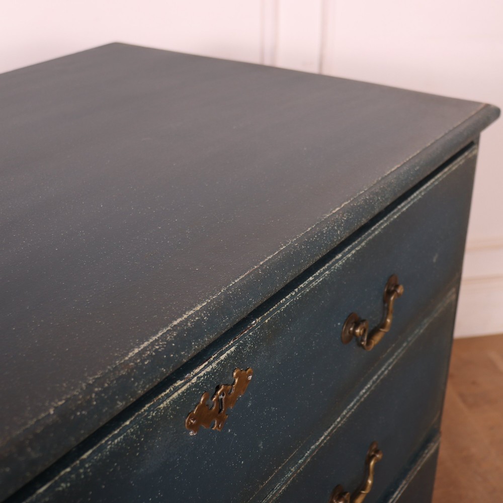 A three-drawer painted wooden chest featuring a dark blue painted finish, brass swan-neck handles, and shaped bracket feet. View IX
