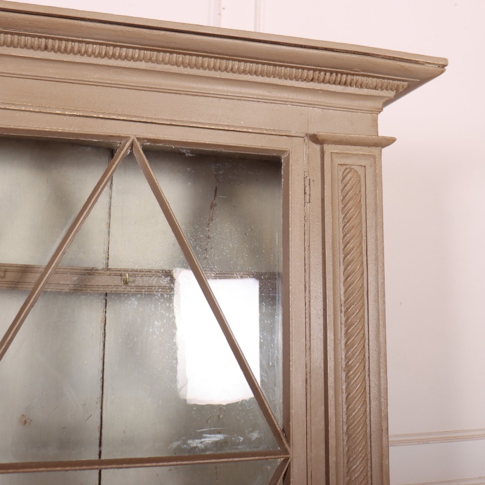 A two-part painted kitchen dresser featuring a glazed upper cabinet with geometric diamond glazing bars over a base with drawers and panelled doors. View III