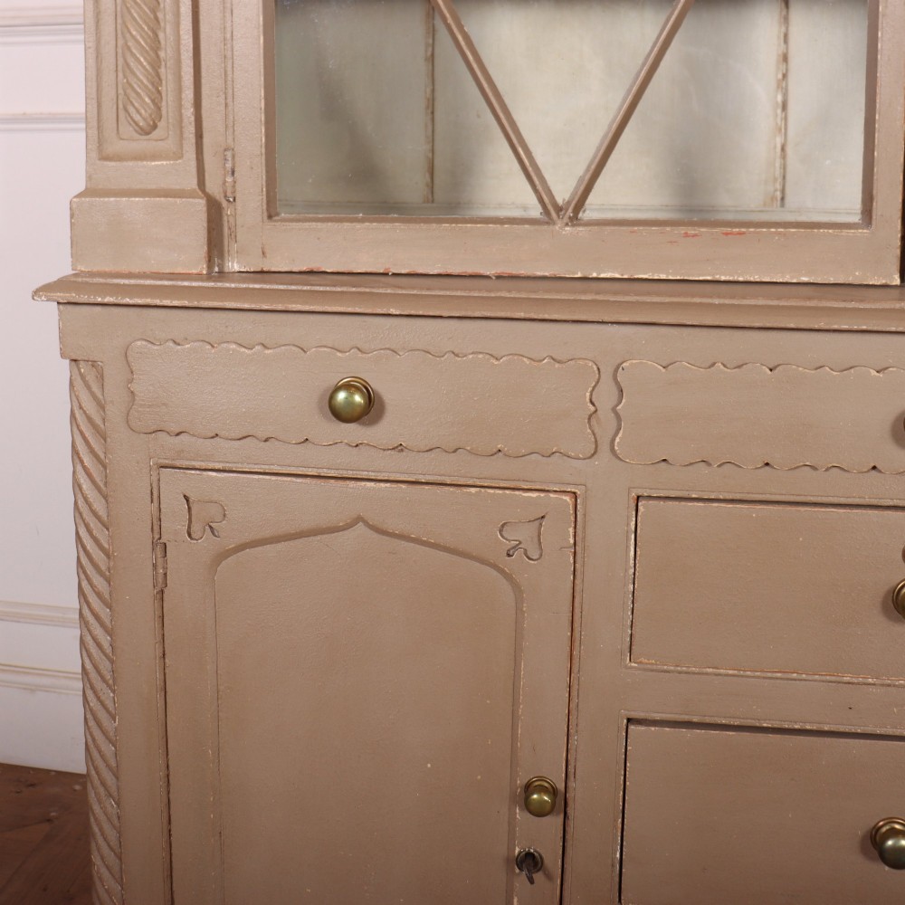 A two-part painted kitchen dresser featuring a glazed upper cabinet with geometric diamond glazing bars over a base with drawers and panelled doors. View IV
