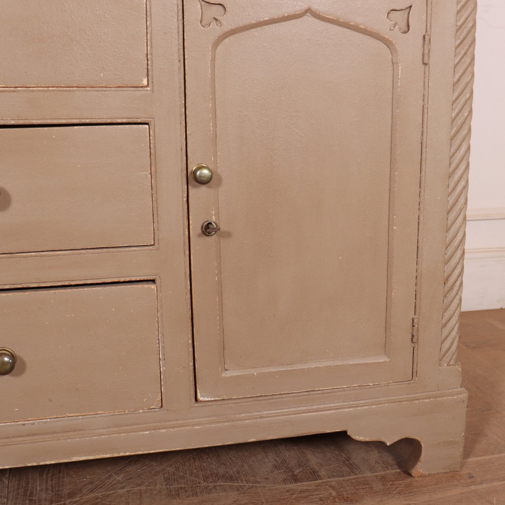 A two-part painted kitchen dresser featuring a glazed upper cabinet with geometric diamond glazing bars over a base with drawers and panelled doors. View VII