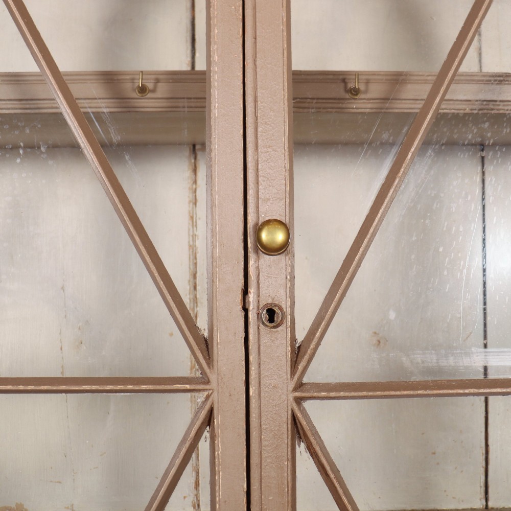 A two-part painted kitchen dresser featuring a glazed upper cabinet with geometric diamond glazing bars over a base with drawers and panelled doors. View IX
