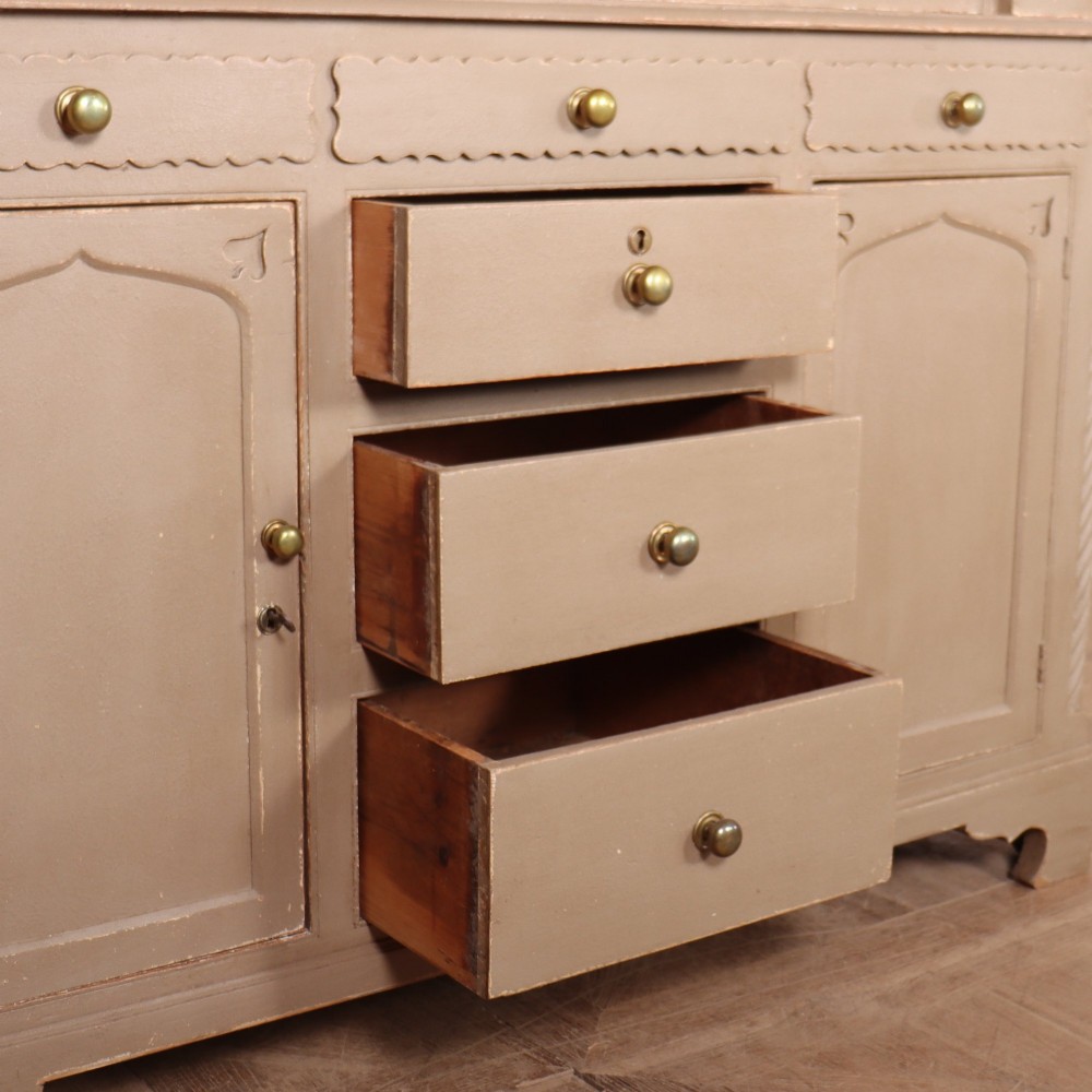 A two-part painted kitchen dresser featuring a glazed upper cabinet with geometric diamond glazing bars over a base with drawers and panelled doors. View XIII