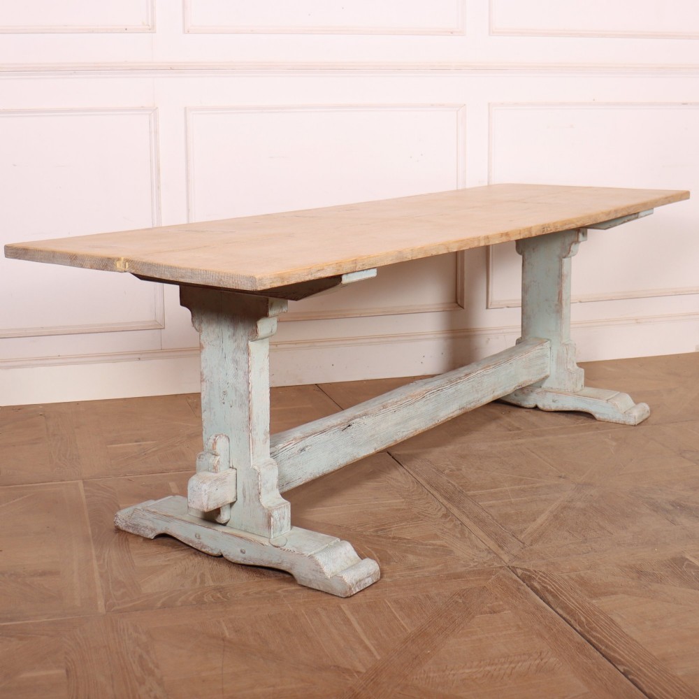 A large Swedish painted trestle dining table with a natural wood scrubbed top and a light blue painted base featuring a pegged stretcher.