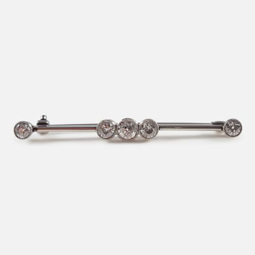 fig 1. An Art Deco 18ct gold bar brooch set with five round diamonds in millegrain bezel settings.