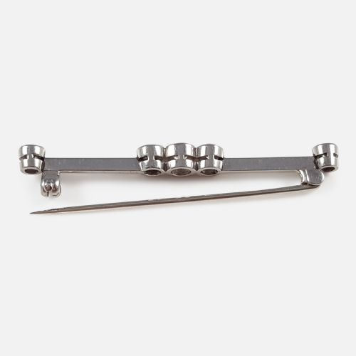 fig 2. An Art Deco 18ct gold bar brooch set with five round diamonds in millegrain bezel settings.