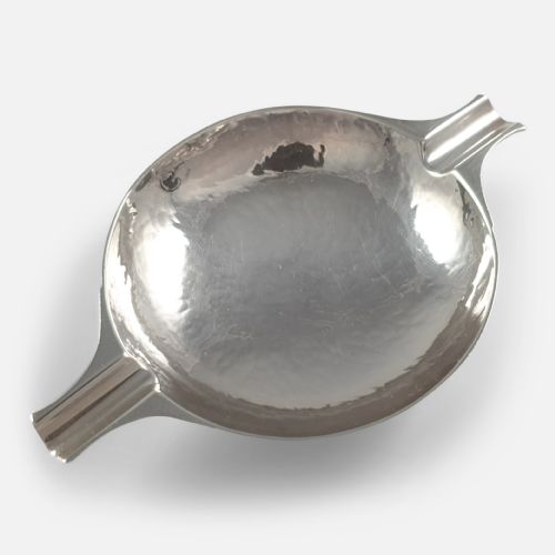 fig 2. A hand-hammered sterling silver round dish featuring two extended rest arms and a raised circular foot rim.