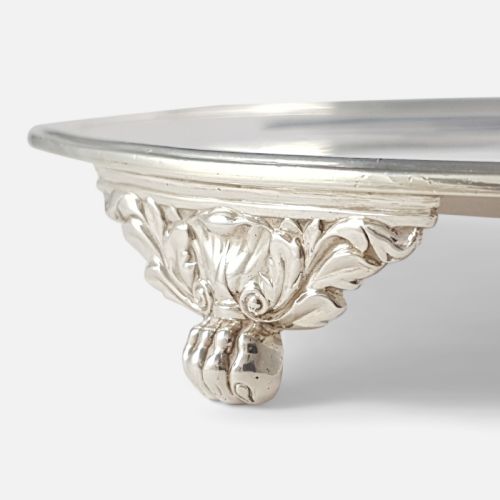 fig 1. A pair of circular 1818 George III sterling silver salvers featuring central engraved crests, moulded rims, and short bracket feet.