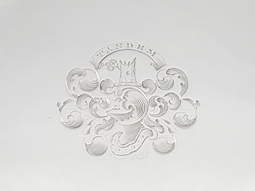 fig 2. A pair of circular 1818 George III sterling silver salvers featuring central engraved crests, moulded rims, and short bracket feet.