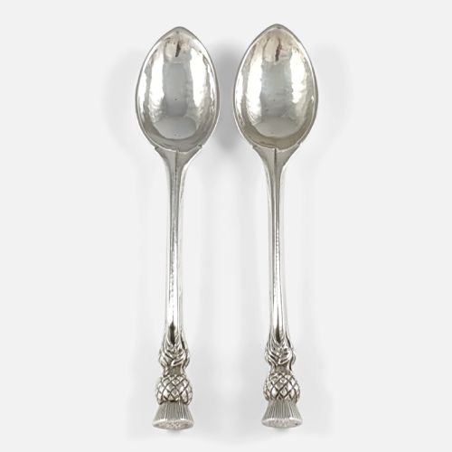 fig 1. A pair of hand-hammered sterling silver spoons featuring decorative thistle finials and tapered stems.