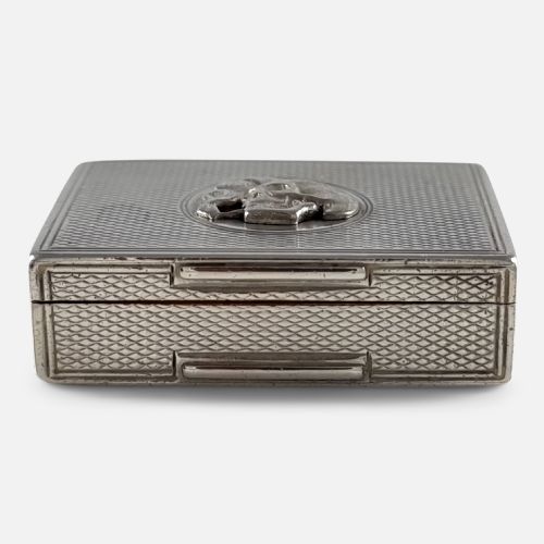 fig 3. A rectangular Victorian sterling silver snuff box with engine-turned lattice engraving and a central circular relief motif of a skull.