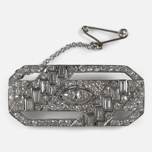 fig 1. A rectangular Art Deco platinum brooch featuring geometric openwork set with round, baguette, and a central marquise-cut diamond.
