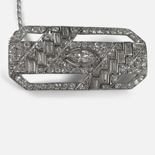 fig 2. A rectangular Art Deco platinum brooch featuring geometric openwork set with round, baguette, and a central marquise-cut diamond.
