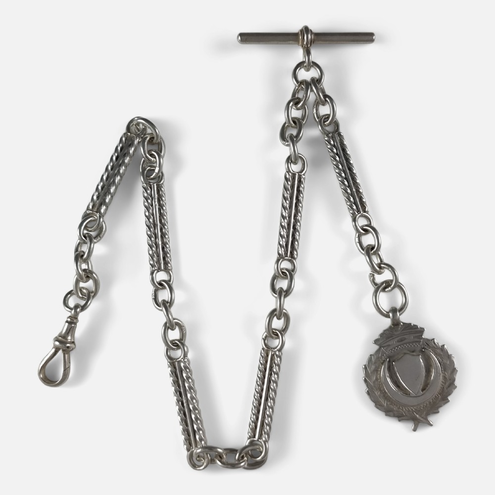 A Victorian sterling silver Albert watch chain featuring fancy twisted bar links, a T-bar fastening, a swivel clip clasp, and a crest-shaped fob.