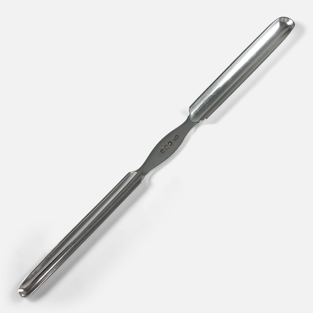 An Edwardian sterling silver double-ended marrow scoop featuring hallmarks stamped along the central waist.
