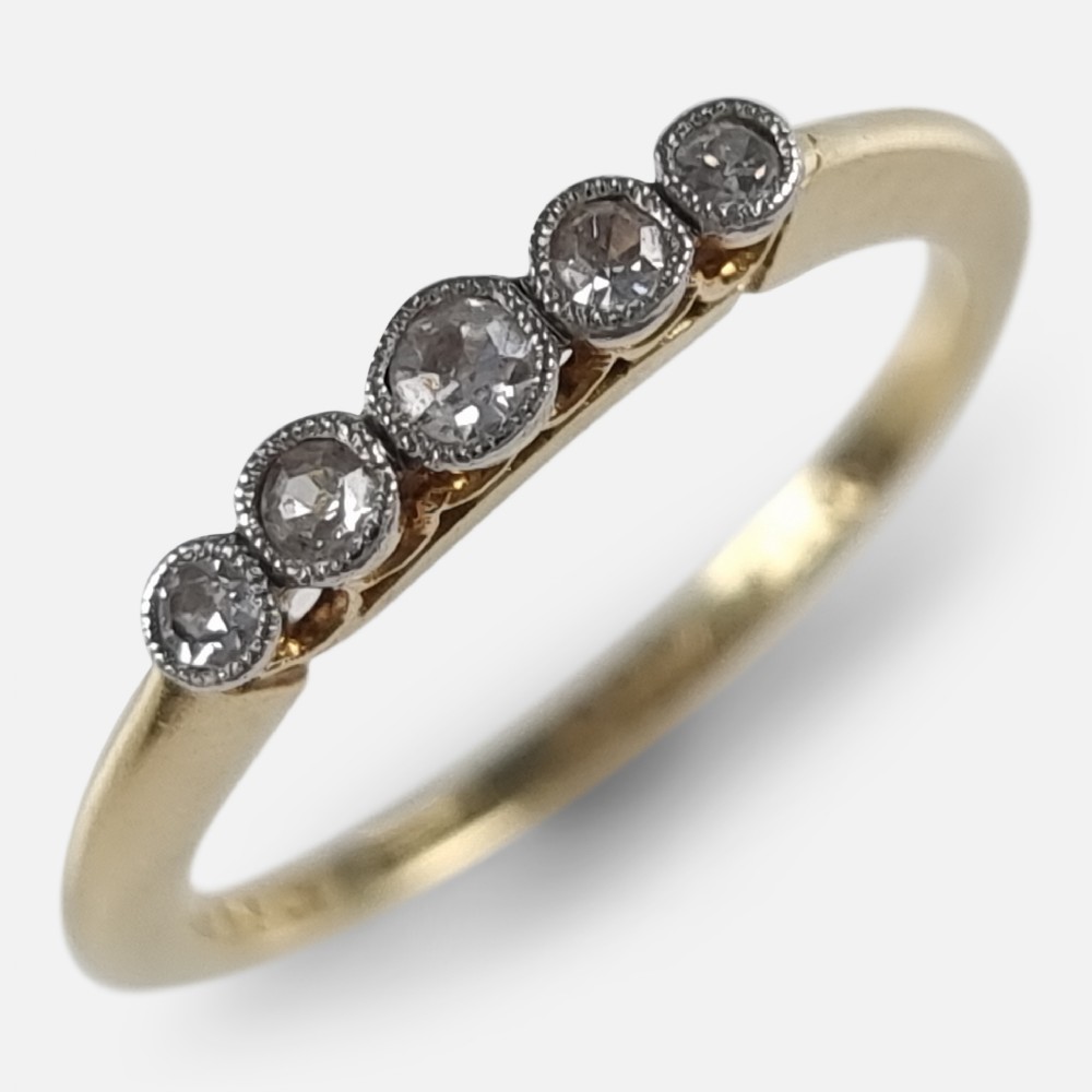 An 18ct yellow gold band mounted with five round diamonds in platinum millegrain rub-over settings.