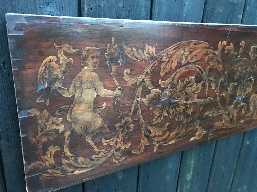 A rectangular antique wooden panel featuring detailed figurative and floral marquetry inlay work in lighter wood tones against a darker wood background. View III