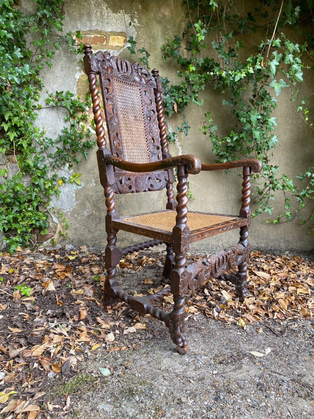 Carved Charles II walnut armchair with barley twist legs, woven cane back and seat panels, and carved crown motif. View II