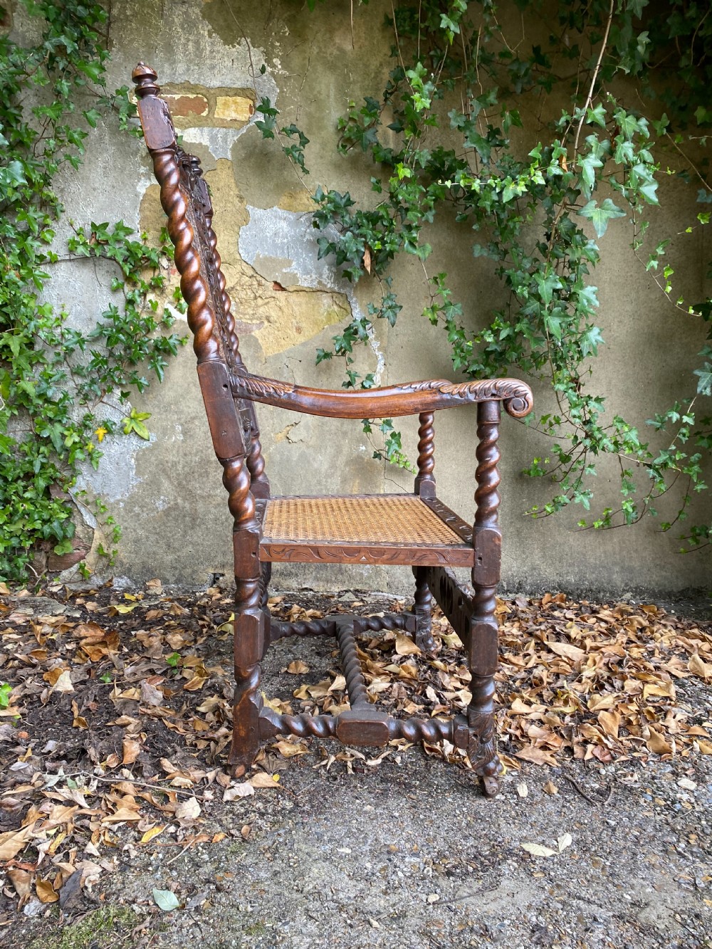 Carved Charles II walnut armchair with barley twist legs, woven cane back and seat panels, and carved crown motif. View III
