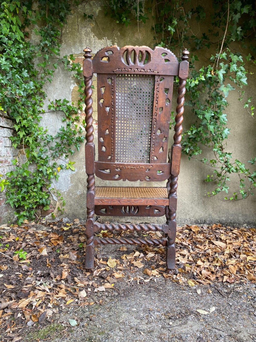 Carved Charles II walnut armchair with barley twist legs, woven cane back and seat panels, and carved crown motif. View IV