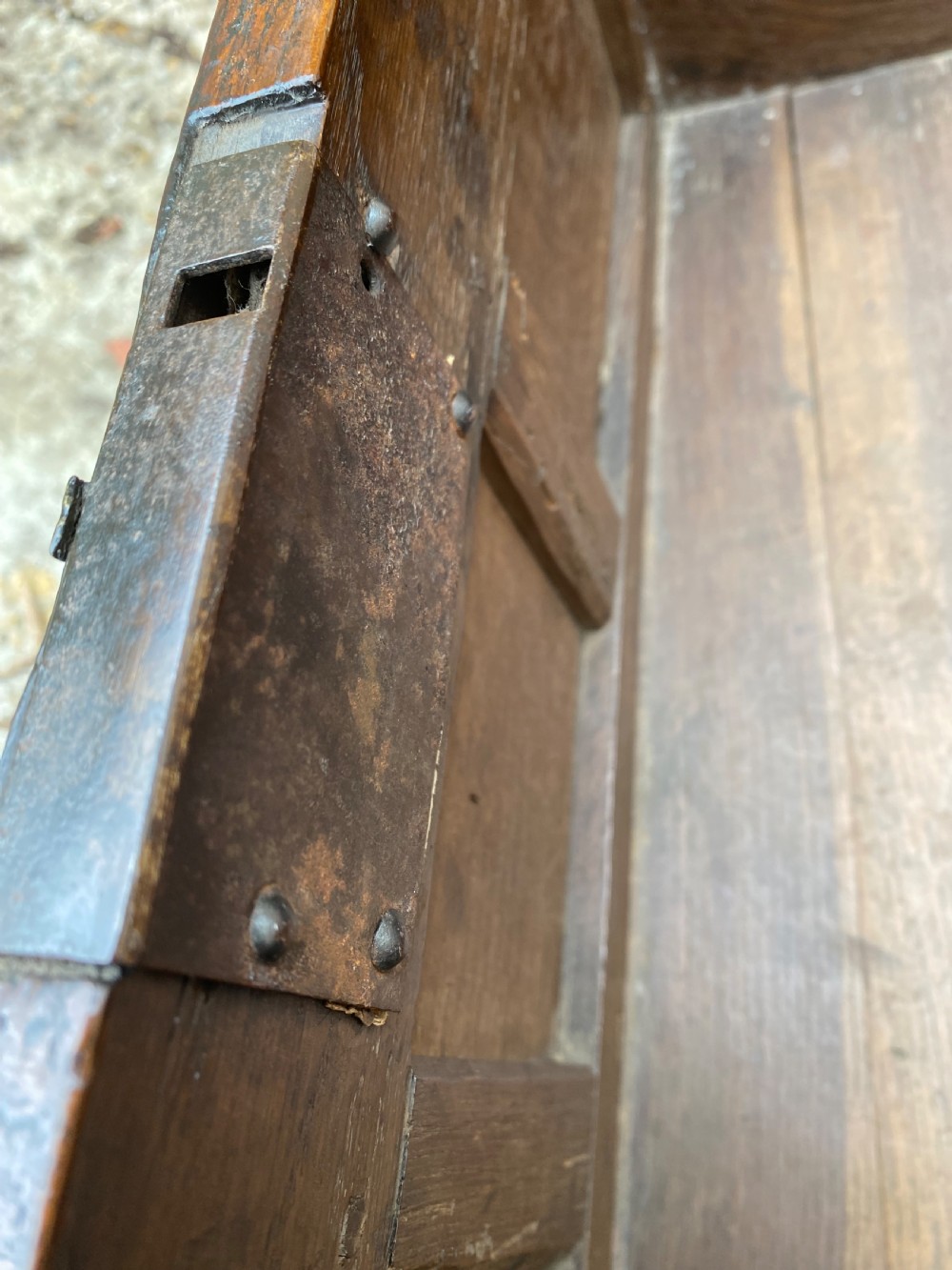 A carved dark oak Georgian coffer bach featuring a hinged lid, relief-carved floral panels, two lower drawers, and bracket feet. View XVI