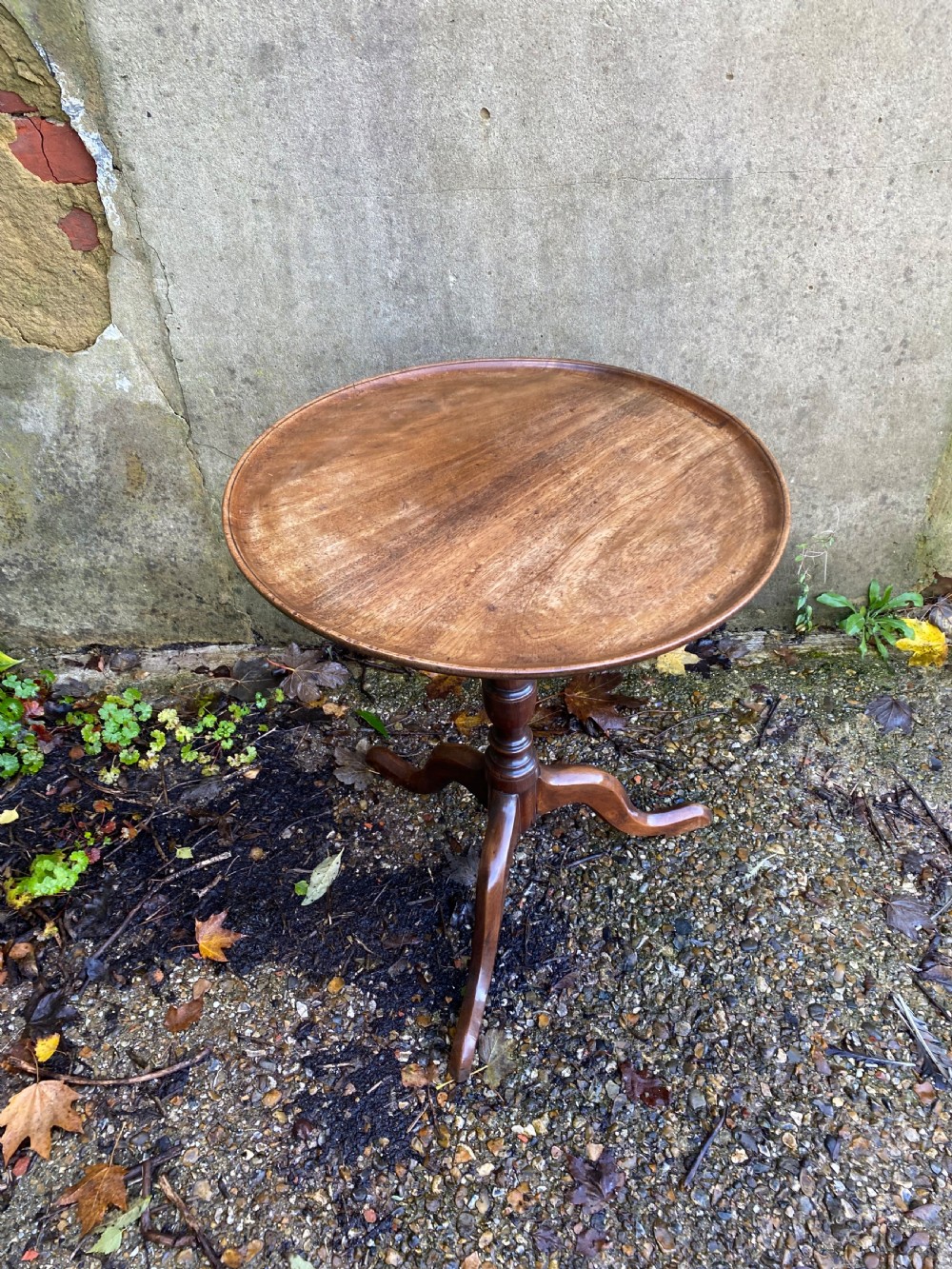 A Georgian mahogany circular side table featuring a dished top, a turned central column, and three tripod cabriole legs. View IV