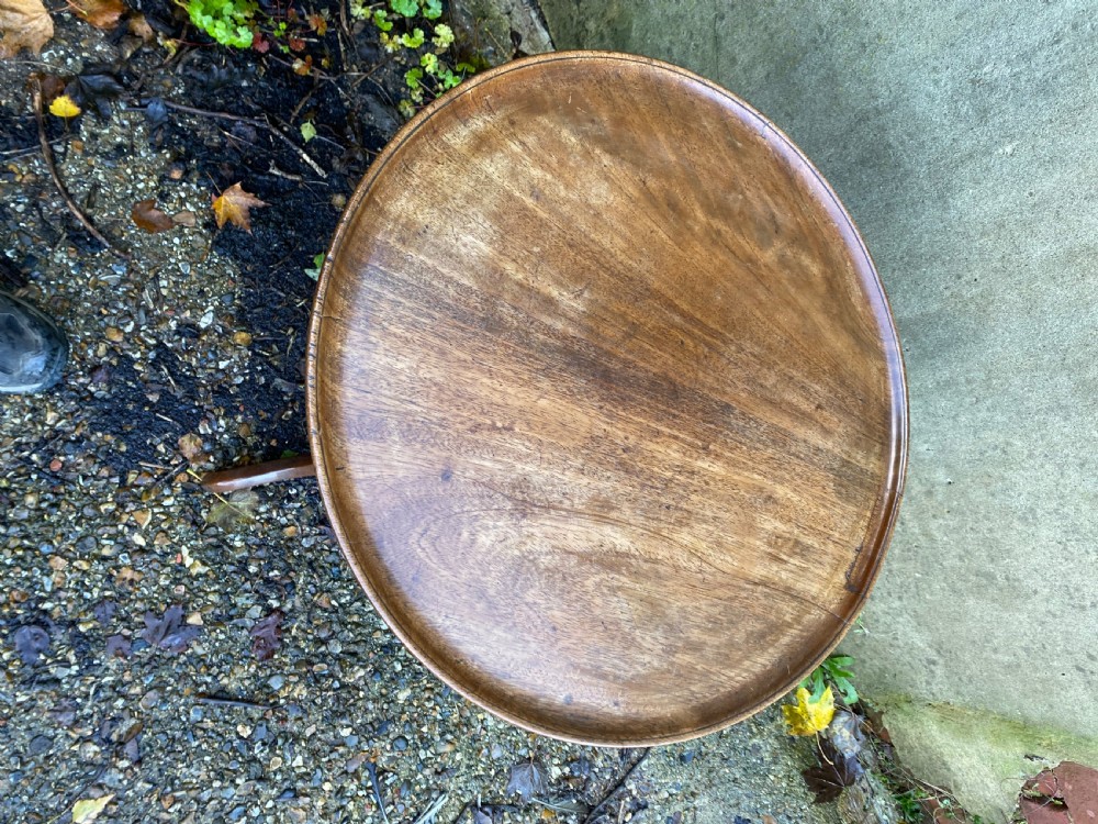 A Georgian mahogany circular side table featuring a dished top, a turned central column, and three tripod cabriole legs. View VI