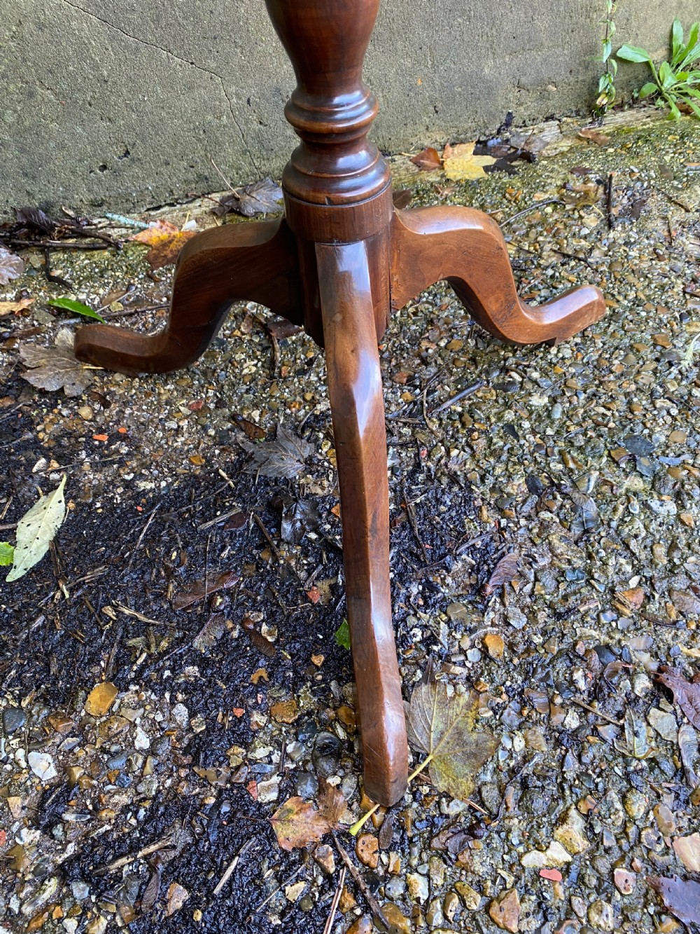 A Georgian mahogany circular side table featuring a dished top, a turned central column, and three tripod cabriole legs. View VII