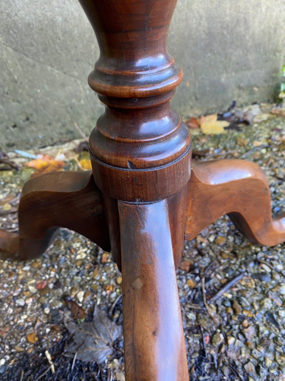 A Georgian mahogany circular side table featuring a dished top, a turned central column, and three tripod cabriole legs. View IX