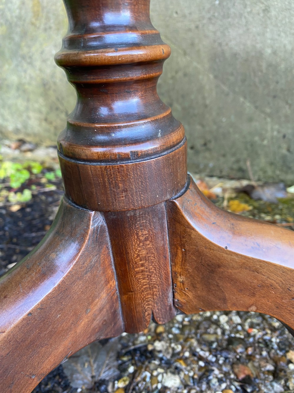 A Georgian mahogany circular side table featuring a dished top, a turned central column, and three tripod cabriole legs. View X