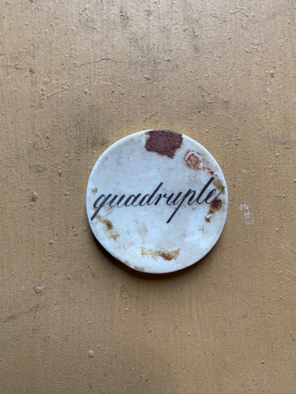 A set of six circular white porcelain gaming tokens decorated with hand-painted playing card king figures and cursive script lettering. View V