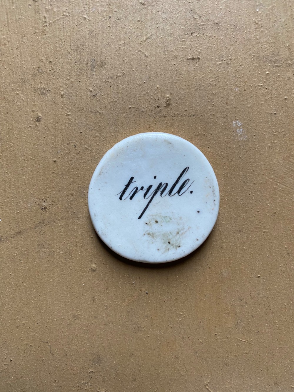 A set of six circular white porcelain gaming tokens decorated with hand-painted playing card king figures and cursive script lettering. View VII
