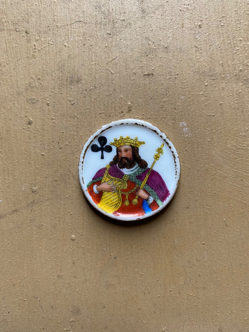 A set of six circular white porcelain gaming tokens decorated with hand-painted playing card king figures and cursive script lettering. View VIII