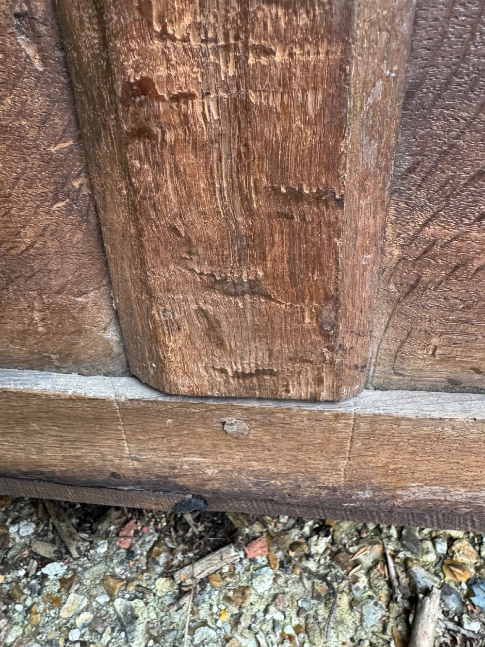 A small dark oak coffer featuring a carved top frieze, a three-panel front, and a central iron escutcheon. View XXIII