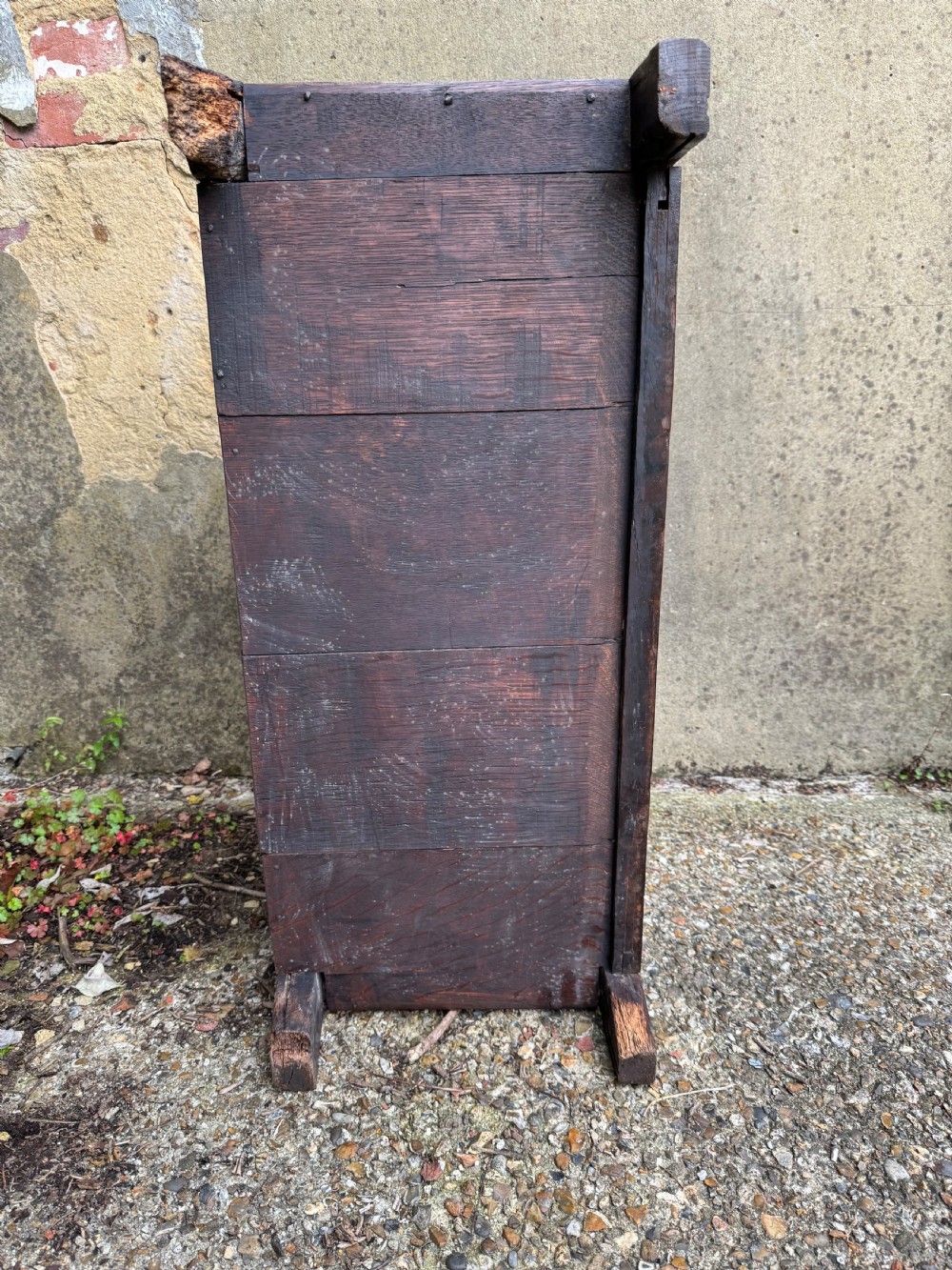 A small dark oak coffer featuring a carved top frieze, a three-panel front, and a central iron escutcheon. View XXV
