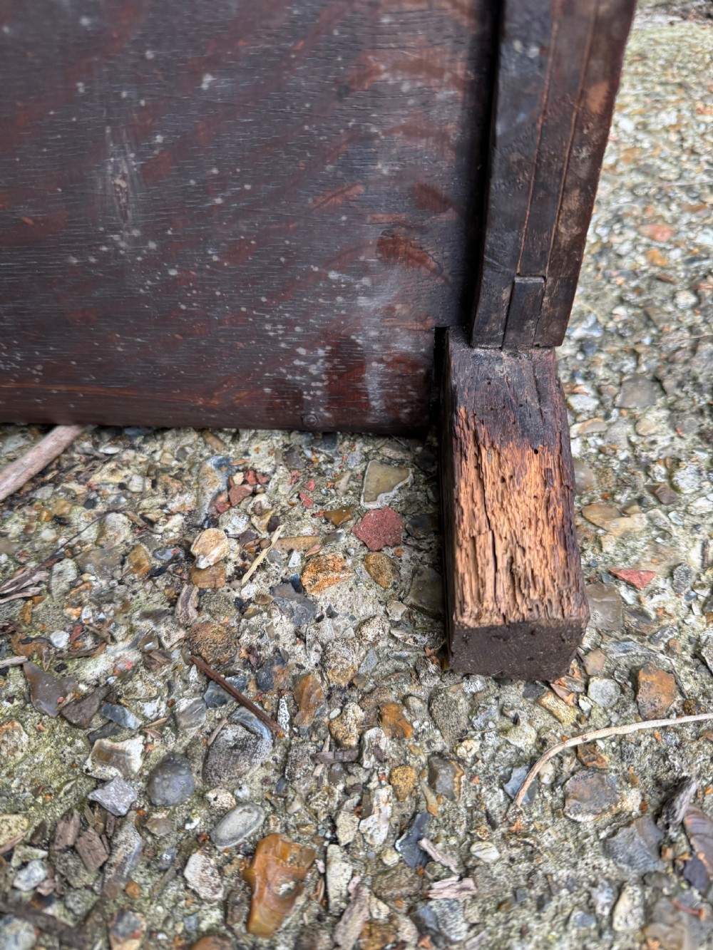 A small dark oak coffer featuring a carved top frieze, a three-panel front, and a central iron escutcheon. View XXVII