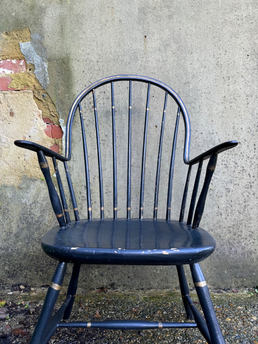 A black-painted wooden Windsor armchair featuring a hoop back with vertical spindles, curved armrests, and turned legs joined by stretchers. View VIII