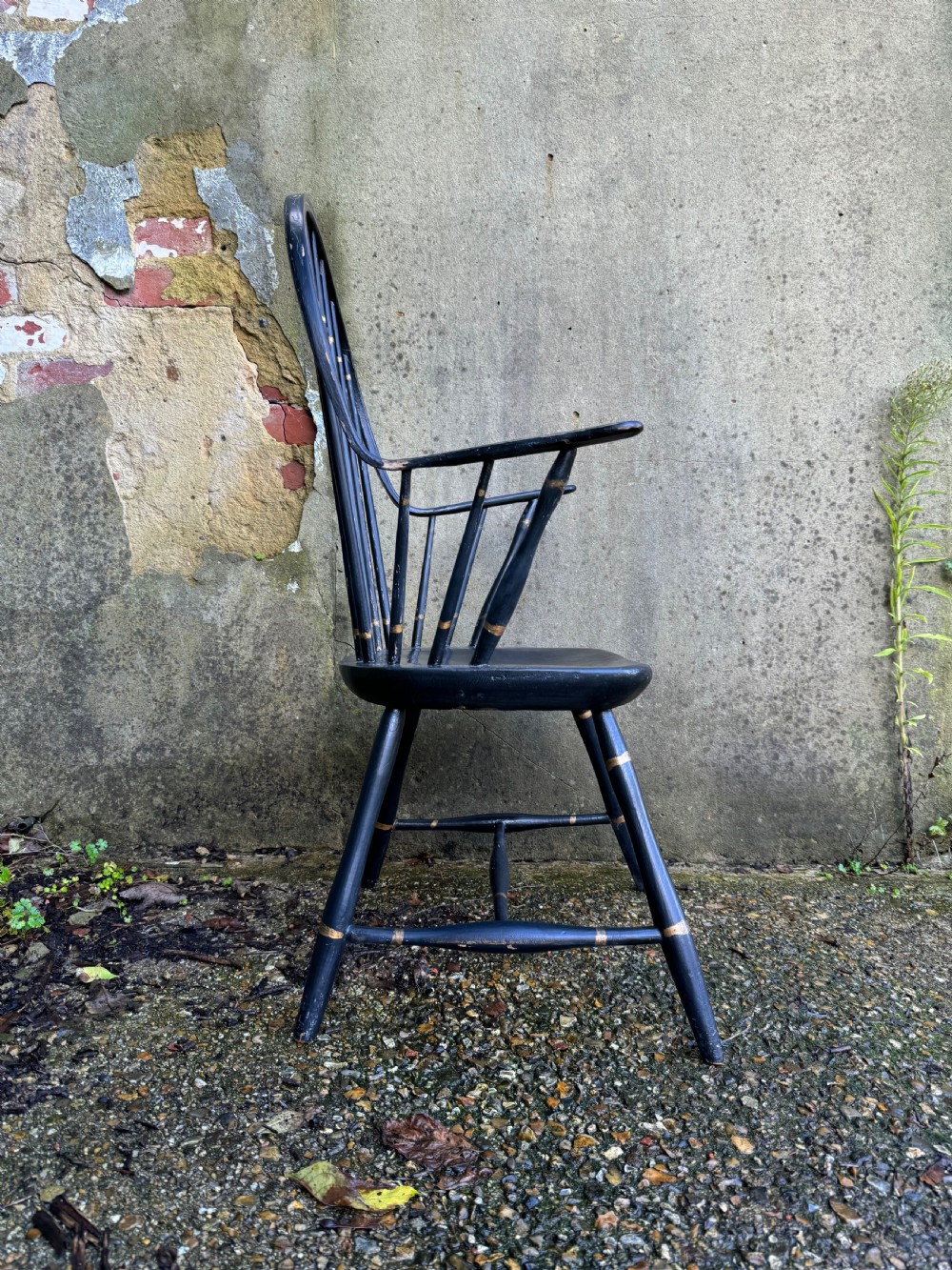 A black-painted wooden Windsor armchair featuring a hoop back with vertical spindles, curved armrests, and turned legs joined by stretchers. View XI