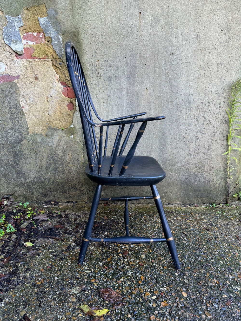 A black-painted wooden Windsor armchair featuring a hoop back with vertical spindles, curved armrests, and turned legs joined by stretchers. View XII