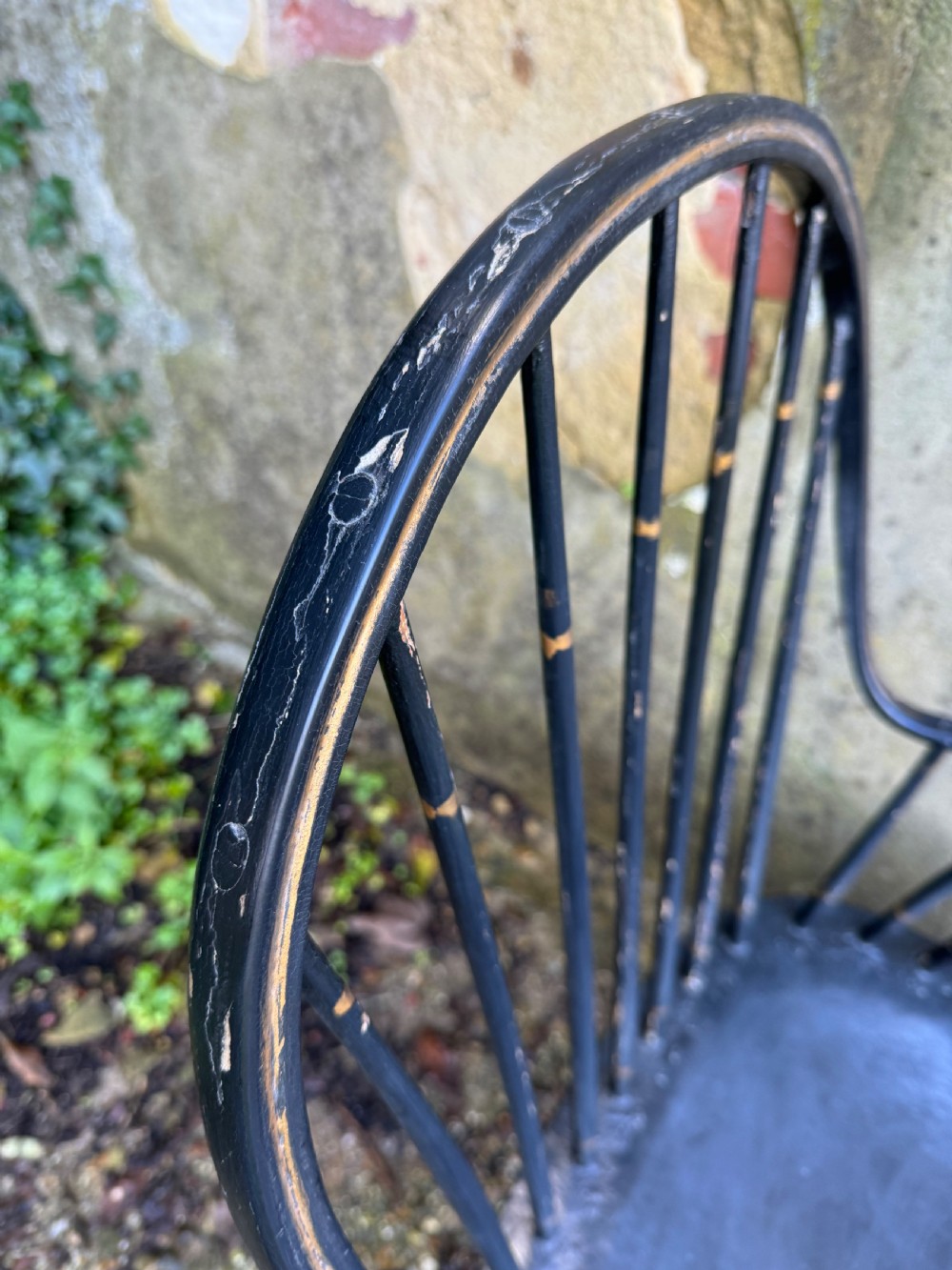 A black-painted wooden Windsor armchair featuring a hoop back with vertical spindles, curved armrests, and turned legs joined by stretchers. View XIII