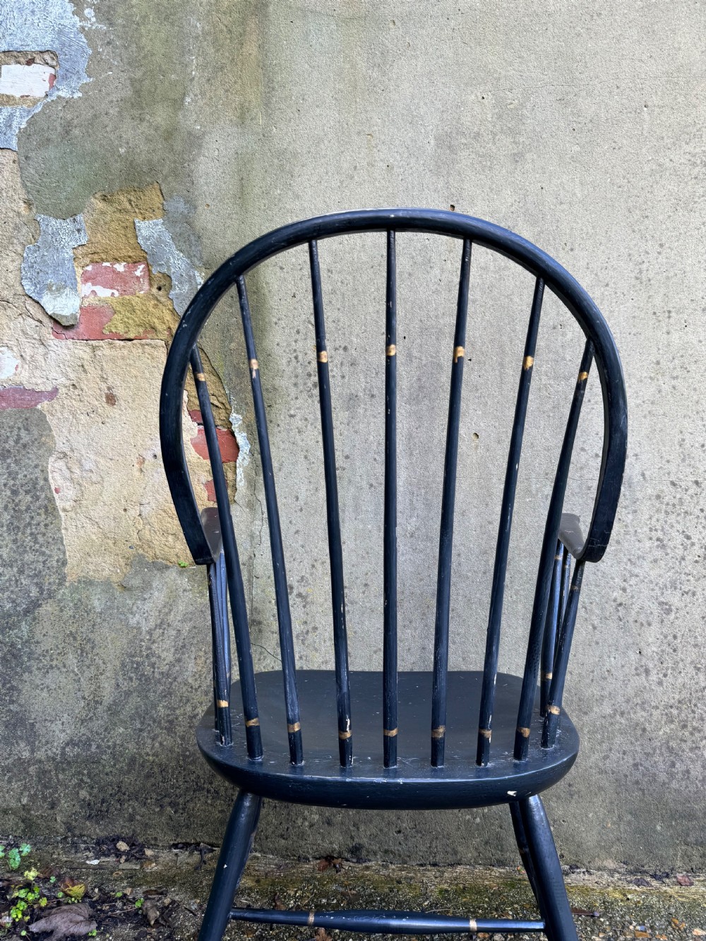 A black-painted wooden Windsor armchair featuring a hoop back with vertical spindles, curved armrests, and turned legs joined by stretchers. View XV